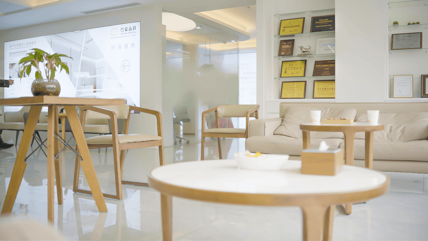 Moderne professionelle Wartezone mit Stühlen und einem beigen Sofa.